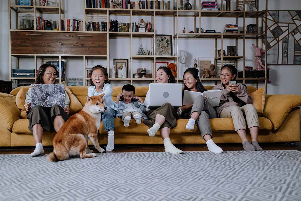some people sitting down in couch inside a dog.